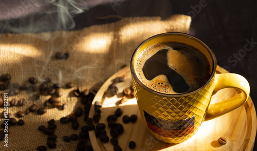 Top view of Colombian coffee cup filled with hot coffee with foam. on a wooden plate with scattered coffee beans on a dark background. Colombian culture and coffee concept