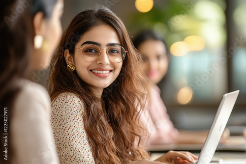 Indian marketing females working on laptop at office photo