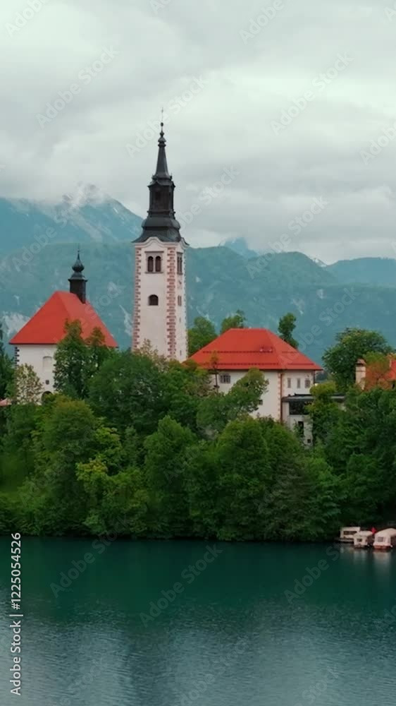 Aerial view of Church of the Assumption of Mary in the center of the lake Bled. Flying around small island on Bled Lake in Slovenia Aerial view of Church of the Assumption of Mary in the center of the lake Bled. Flying around small island on Bled Lake in Slovenia