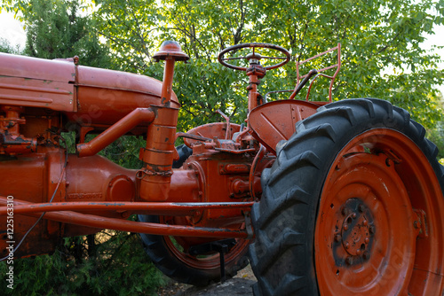 A red tractor in a forest area. Ideal for small land plots where high power is not required, providing efficient and reliable operation.