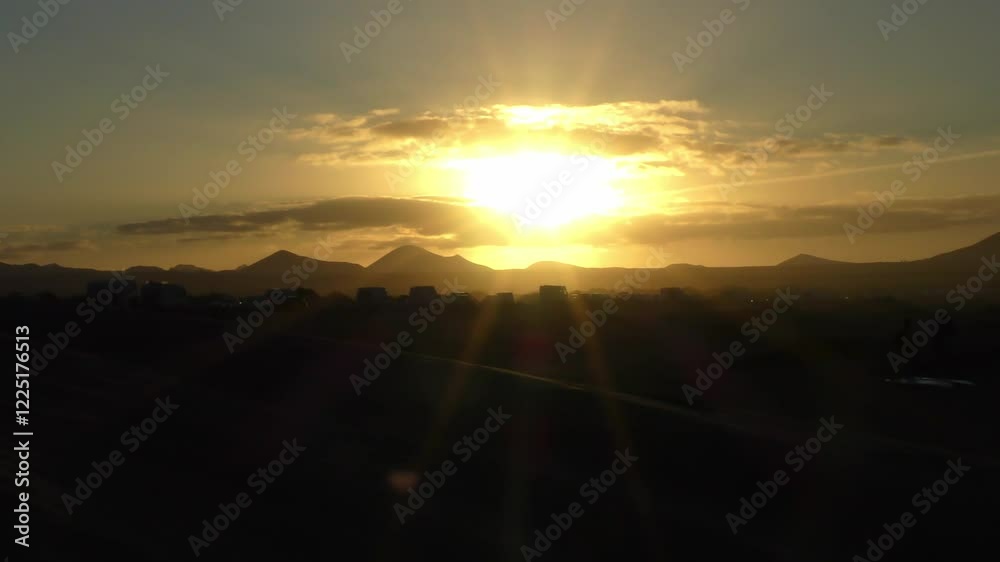 stimmungsvoller Sonnenuntergang über den Vulkanberggipfeln auf Lanzarote, Sonnenstrahlen, Urlaub, Idylle, Lanzarote, Kanaren, Landschaft, Bergsilhouetten 
