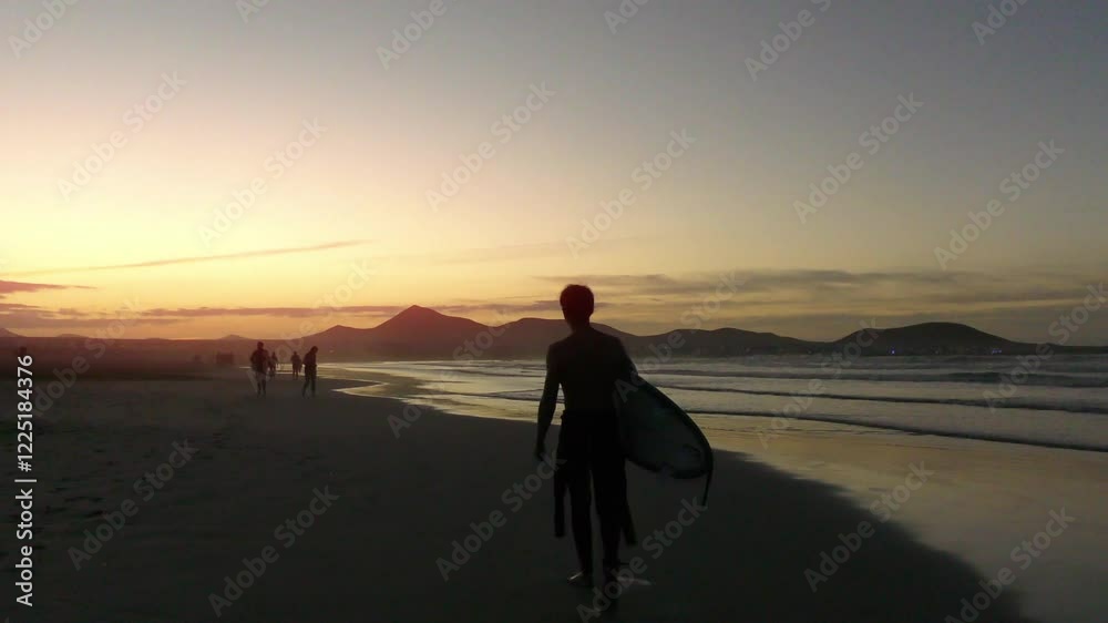 Strand mit Surfer in der Abendsonne bei stimmungsvollem Sonnenuntergang, Meer, Wellenreiter, Urlaub, Idylle, Lanzarote, Kanaren, Küste, Landschaft, Bergsilhouetten Strand mit Surfer in der Abendsonne bei stimmungsvollem Sonnenuntergang, Meer, Wellenreiter, Urlaub, Idylle, Lanzarote, Kanaren, Küste, Landschaft, Bergsilhouetten