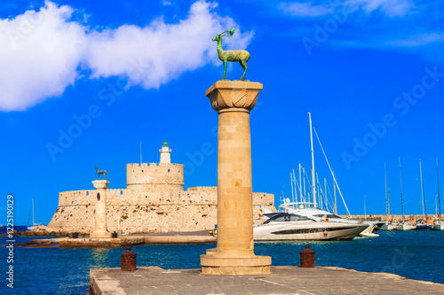 Rhodes island, Greece, Dodecanese.  Famous Mandraki bay and marina. view of lighthouse and column with deer.