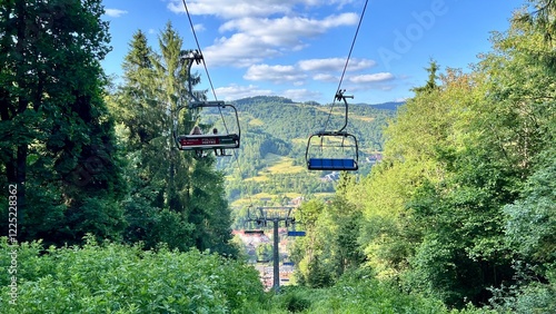Horizontal photo of a funicular going up the mountain among trees in summer, in Szczawnica, Pieniny National Park, Poland. Perfect for active lifestyle, hiking, traveling, and outdoor adventure themes