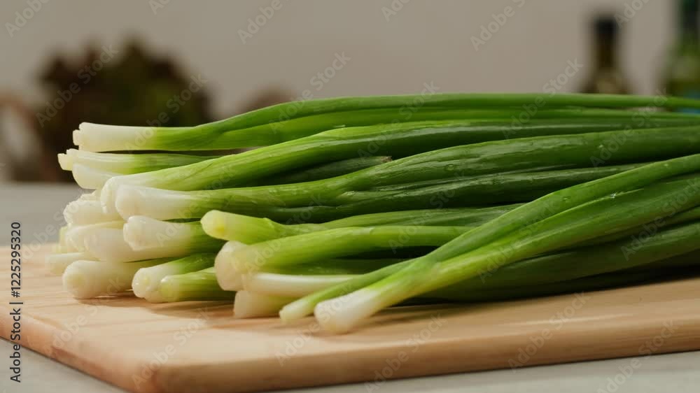Cutting fresh green onions on a cutting board, close up chef cooking green vegan salad. Cutting fresh green onions on a cutting board, close up chef cooking green vegan salad.