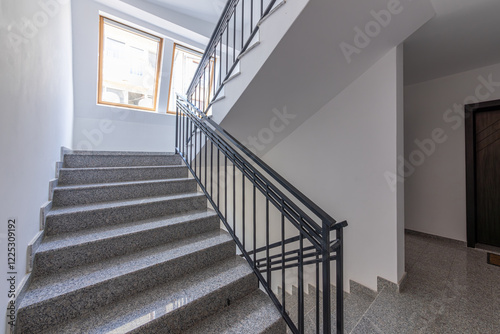 Modern stair case between floors. Stairs with metallic rail in modern building