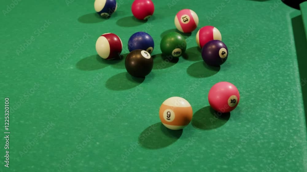 Young man playing American billiard pool poule close-up. Colorful balls on green billiards table .Billiard balls with numbers on a pool table. Billiards team sport. Young man playing American billiard pool poule close-up. Colorful balls on green billiards table .Billiard balls with numbers on a pool table. Billiards team sport.