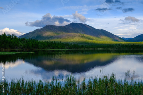 Sunset panorama of small lake with mountain reflection in Siberia, Buryatia, Russia