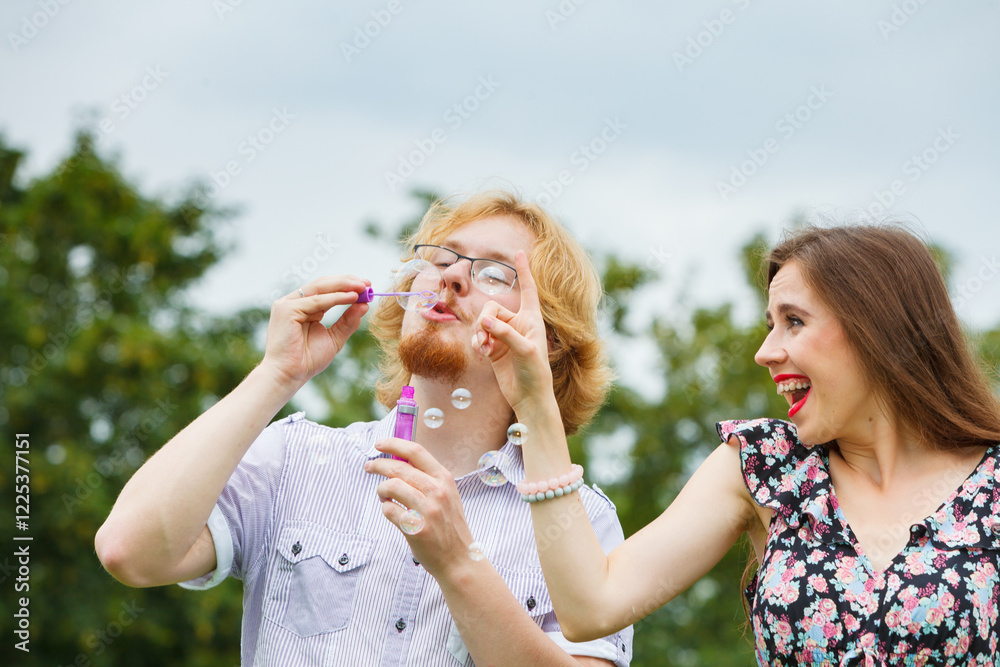 Obraz premium Couple blowing soap bubbles, having fun
