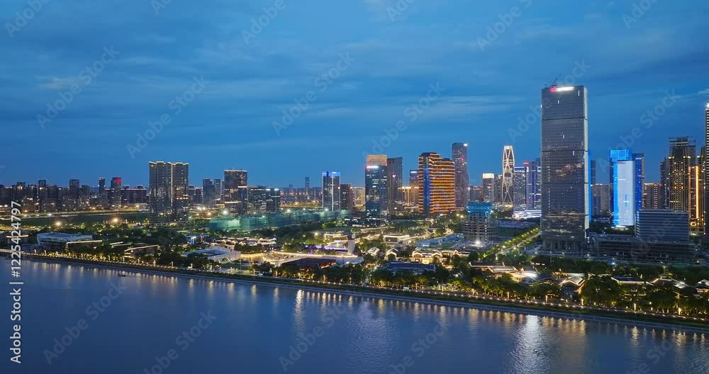 Aerial shot of illuminated modern cityscape with river and architecture in Hangzhou, China Aerial shot of illuminated modern cityscape with river and architecture in Hangzhou, China