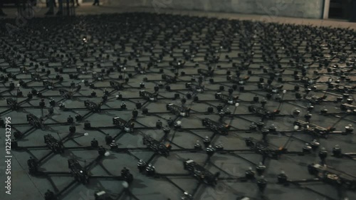 Young people lay out fpv drones and quadcopters on the floor.