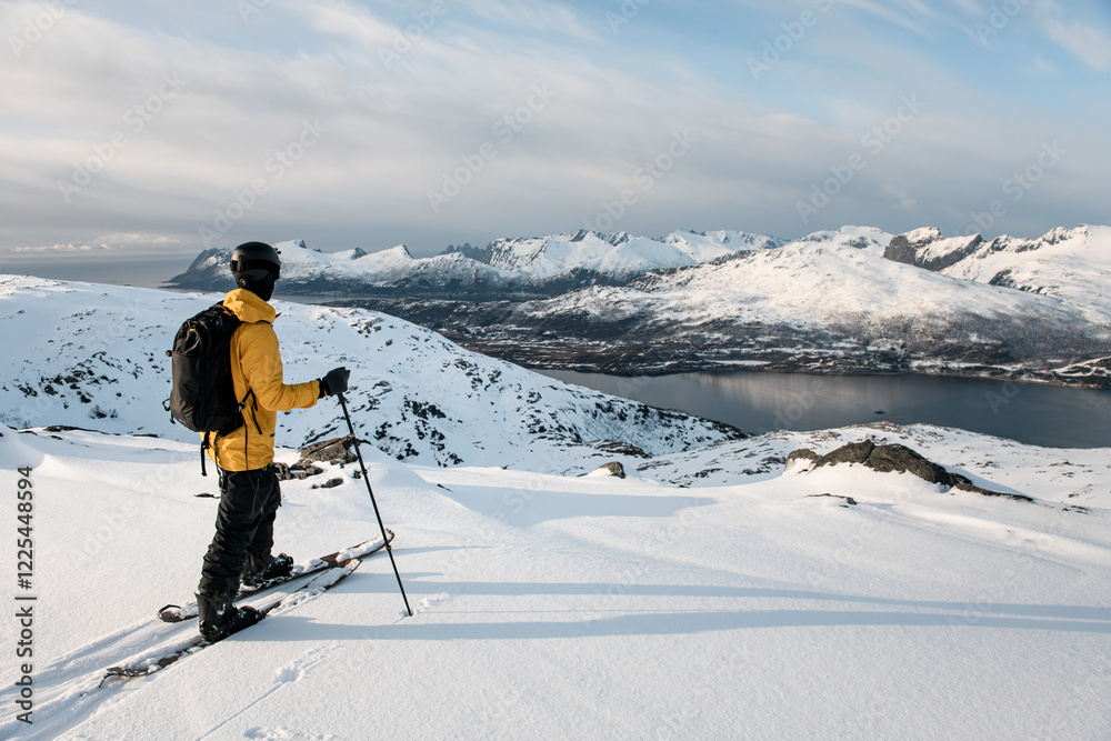 Skier tourist reached the mountain river on skis and admires the beautiful mountain landscape Skier tourist reached the mountain river on skis and admires the beautiful mountain landscape