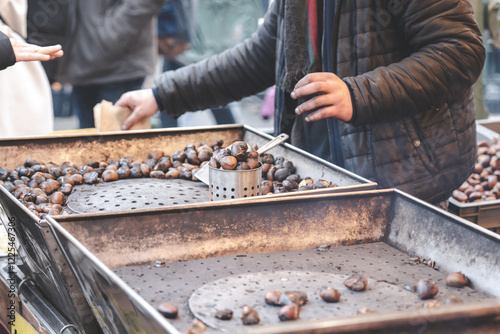 Warm chestnuts roasting at a bustling market during a chilly evening