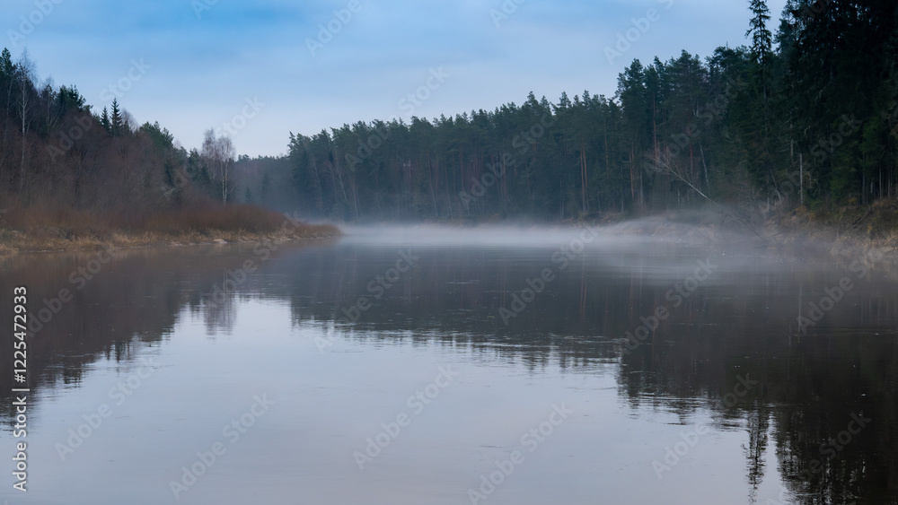 Foggy Morning Over a Calm River with Reflections of Trees - Tranquil Wilderness Scene Foggy Morning Over a Calm River with Reflections of Trees - Tranquil Wilderness Scene