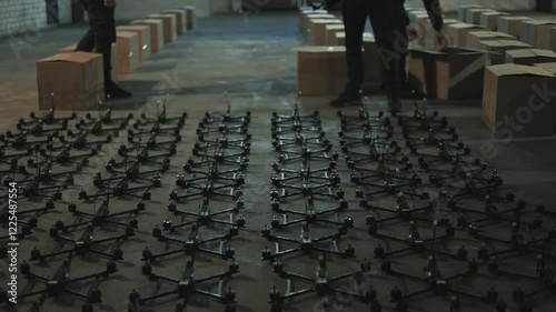 Young people lay out fpv drones and quadcopters on the floor.