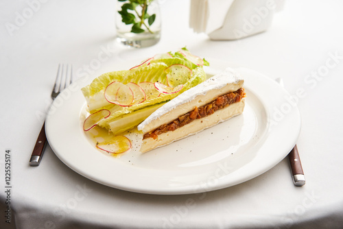 Brie cheese layered with onion marmalade. Served with summer salad greens. Restaurant serving, fancy restaurant. photo