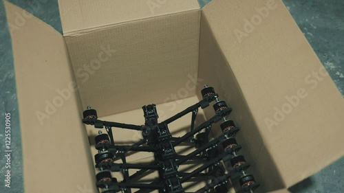 Young people lay out fpv drones and quadcopters on the floor.