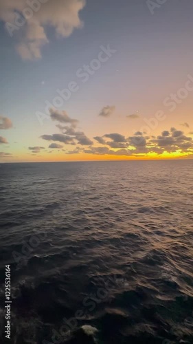 Panoramic view of the ocean and lifeboats from a cruise at sunset