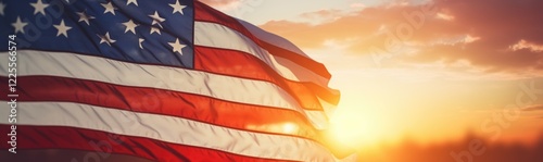 The American flag waves proudly against a backdrop of a stunning sunset, filling the sky with warm hues while illuminating the surrounding landscape. photo