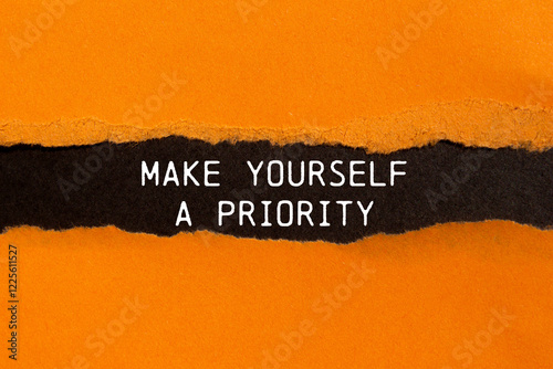 Make yourself a priority message written on ripped torn orange paper with black background. Conceptual make yourself a priority symbol. Copy space. photo