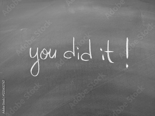 Motivational phrase you did it handwritten on a chalkboard background with simple white script photo