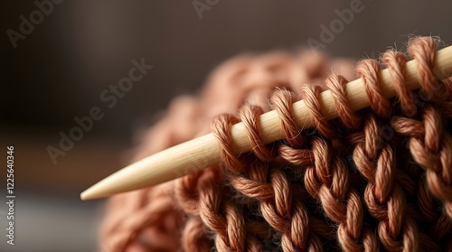 close up of a wooden knitting needle with warm brown yarn, space for copy