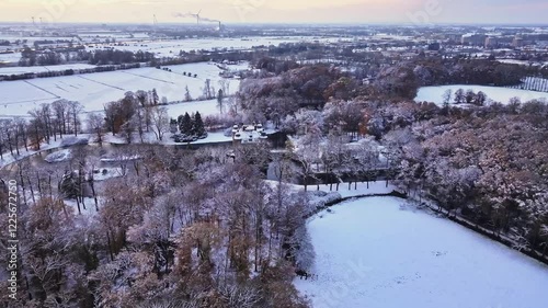 Aerial view of a beautiful snowy landscape featuring Castle Biljoen at sunrise surrounded by trees and water, Velp, Gelderland, Netherlands. photo