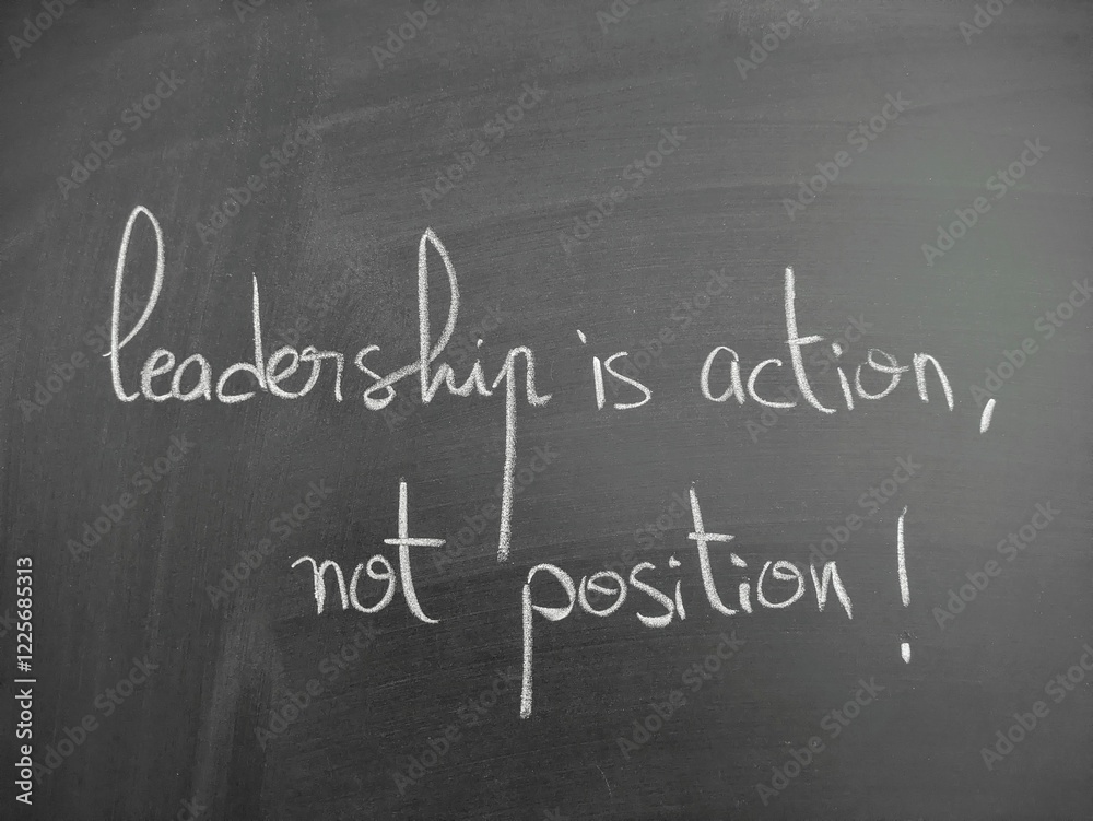 Obraz premium Inspirational quote on leadership written in handwriting on a chalkboard expressing thoughtful guidance and motivational wisdom in an educational setting. Leadership is action not position