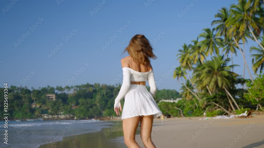 Happy lady playfully running along the ocean shore. Pretty woman laughing, enjoying summer vacation near seaside. Smiling model having fun on tropical sandy beach, palm trees. Follow me. Slow motion. Happy lady playfully running along the ocean shore. Pretty woman laughing, enjoying summer vacation near seaside. Smiling model having fun on tropical sandy beach, palm trees. Follow me. Slow motion.