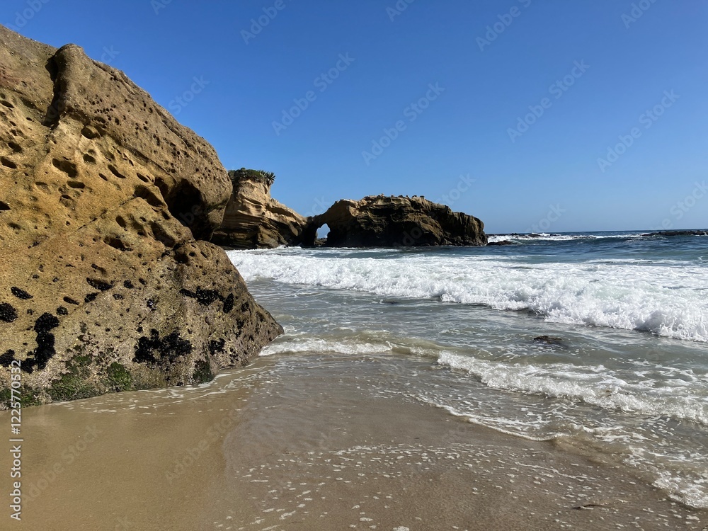 View of Laguna Beach coastline in Southern California with natural rock arch in the background View of Laguna Beach coastline in Southern California with natural rock arch in the background