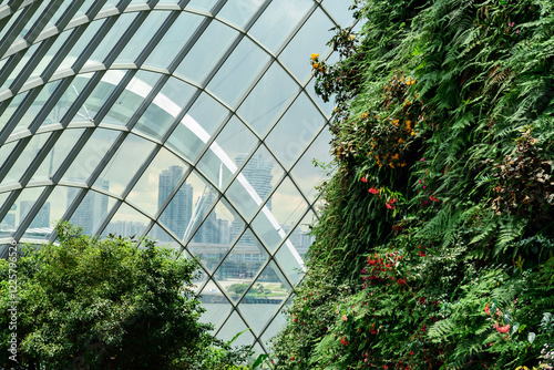 Canvas Print A lush vertical garden inside a modern glass greenhouse with a panoramic view of a futuristic city skyline through the geometric glass panels