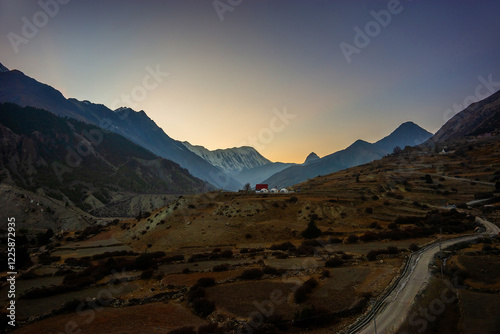 Sunset view of the Himalaya mountains in Manang village. Tilicho peak, a route to Khangsar village and Manang Basecamp hotel after sunset. photo