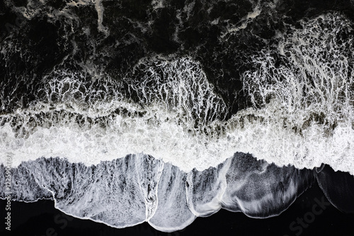 Aerial drone view of epic ocean waves crashing on the shoreline black beach Reynisfjara in Iceland in VIK Myrdal in Golden Circle Area