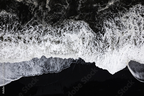 Aerial drone view of epic ocean waves crashing on the shoreline black beach Reynisfjara in Iceland in VIK Myrdal in Golden Circle Area photo