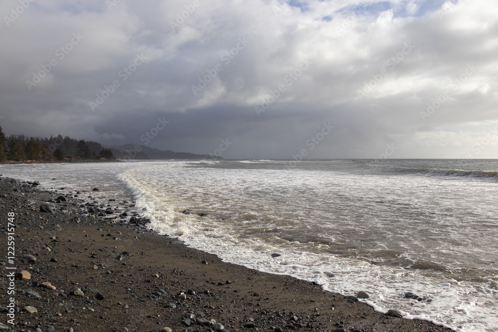 Waves breaking on a rocky beach on a cloudy winter day Waves breaking on a rocky beach on a cloudy winter day