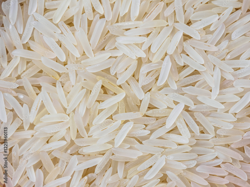 Close-up shot of dry, uncooked long grain basmati rice. Grains are slender and translucent, natural texture. Close-up shot of dry, uncooked long grain basmati rice. Grains are slender and translucent, natural texture.
