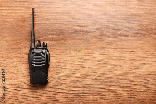 One walkie talkie on wooden table, top view. Space for text photo