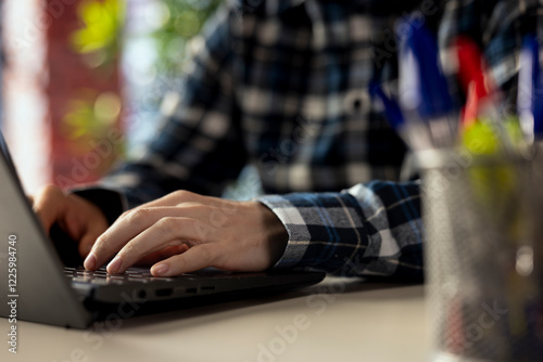 Worker at desk completing spreadsheets on notebook, entering numerical data into cells, calculating totals. Close up of man analyzing figures, creating charts, using spreadsheet software functions photo