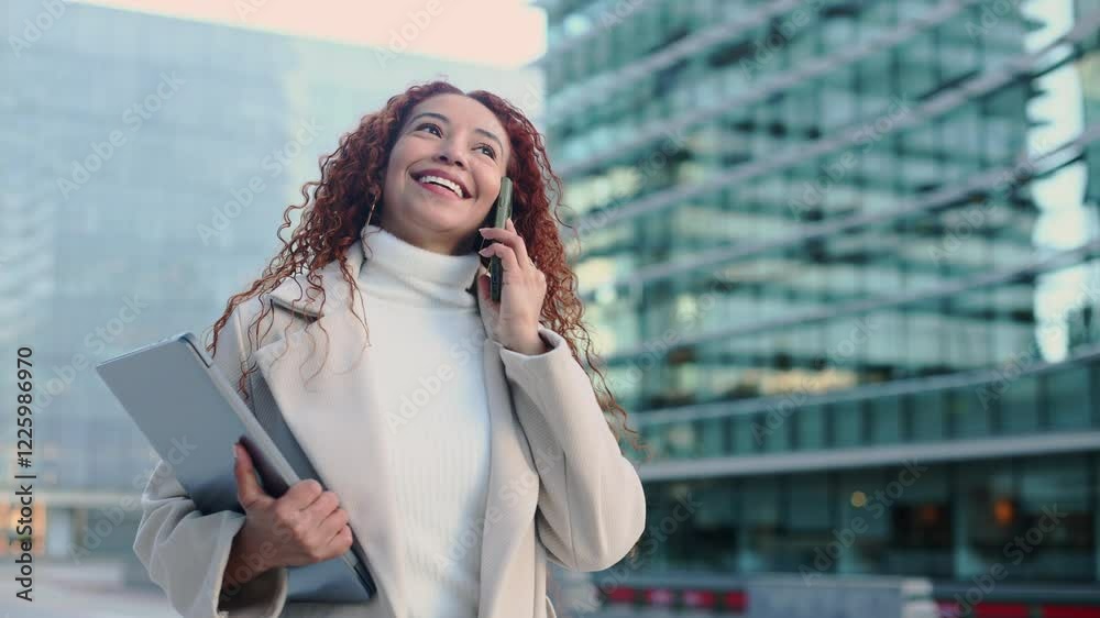 Mixed race woman in urban setting holding tablet and phone