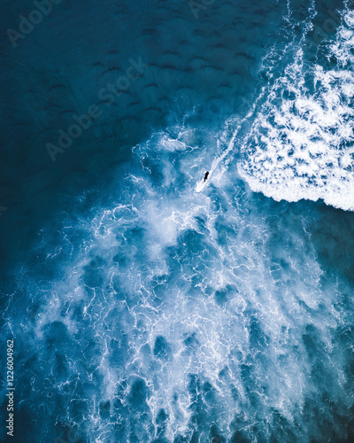 Aerial view of surfer navigating blue waves in Portugal photo