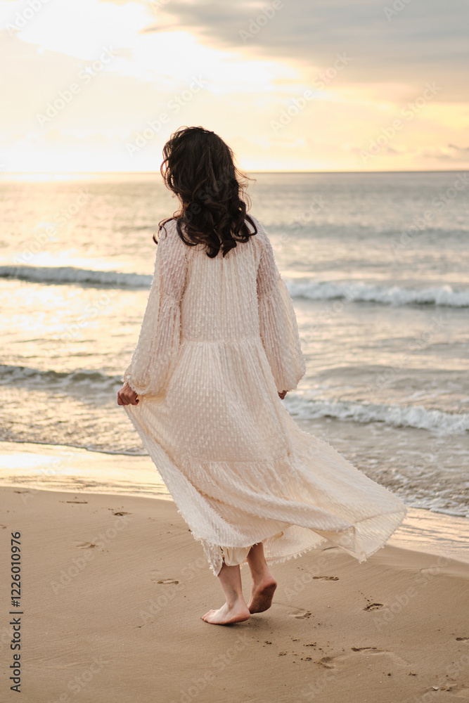 Serene woman in a flowing white dress walks along a sandy beach at sunset. Peaceful ocean waves and golden light create a tranquil atmosphere. Perfect for travel, fashion, or relaxation themes. Serene woman in a flowing white dress walks along a sandy beach at sunset. Peaceful ocean waves and golden light create a tranquil atmosphere. Perfect for travel, fashion, or relaxation themes.