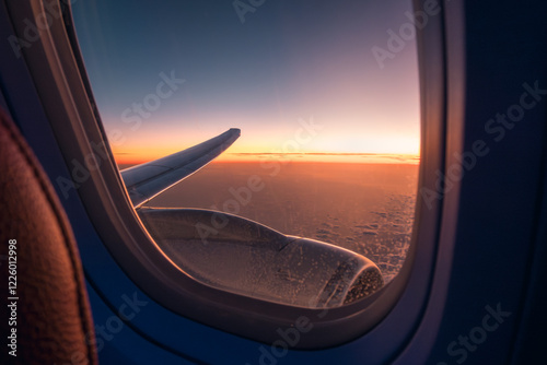 View from airplane window showing wing and sunset photo