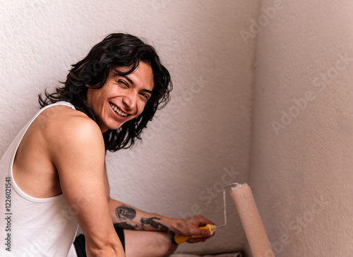Man joyfully painting a wall during home remodeling