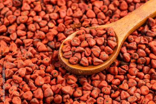 Red organic annatto seeds in the spoon - Bixa Orellana photo