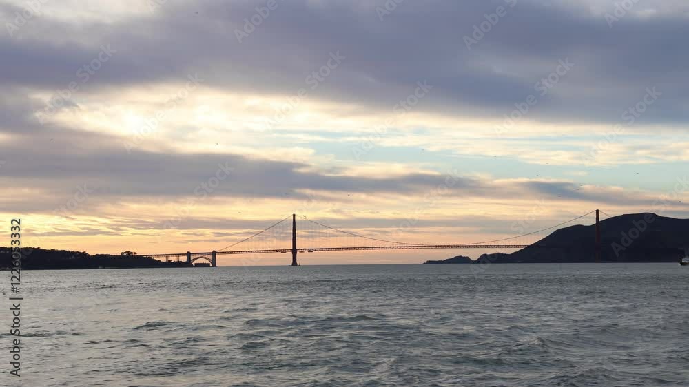 The iconic Golden Gate Bridge towering over the shimmering sea, set against a backdrop of blue skies and distant hills. The vibrant orange-red color of the bridge contrasts beautifully with the calm The iconic Golden Gate Bridge towering over the shimmering sea, set against a backdrop of blue skies and distant hills. The vibrant orange-red color of the bridge contrasts beautifully with the calm