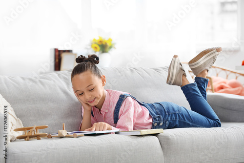 Cute little girl reading ad...