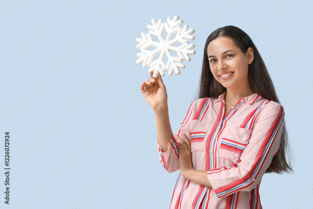Happy young woman with decorative snowflake on blue background Happy young woman with decorative snowflake on blue background