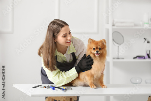 Female groomer brushing Pom...