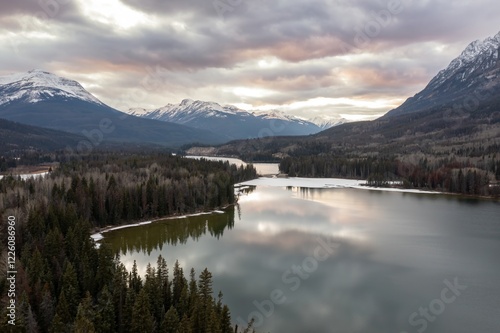 Snowy mountain range reflecting on a serene winter Yellowhead Lake. Peaceful winter landscape.  Jasper National Park, British Columbia, Canada photo