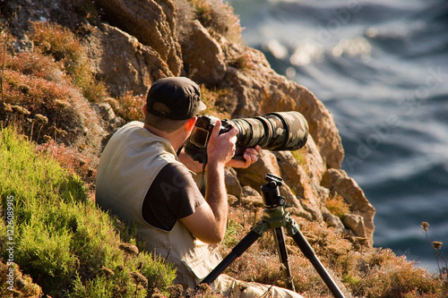 photographers stationed to film and photograph Eleonora's falcon on the cliffs of San Pietro Island, Sardinia Italy